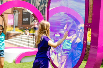 A child looks at her reflection