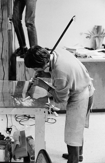 Susan using a crowbar to create an image on an etching plate, 1986